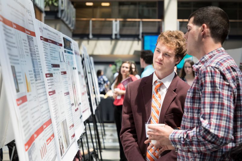 Students Presenting a Poster at Conference 